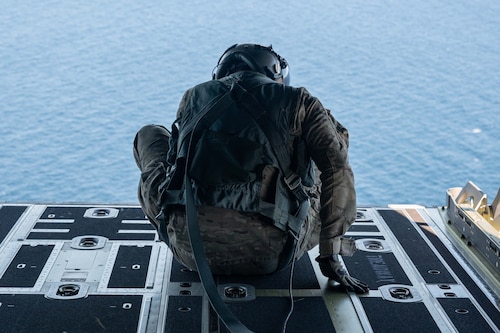 Pictured above is a man staring out the back of an airplane.