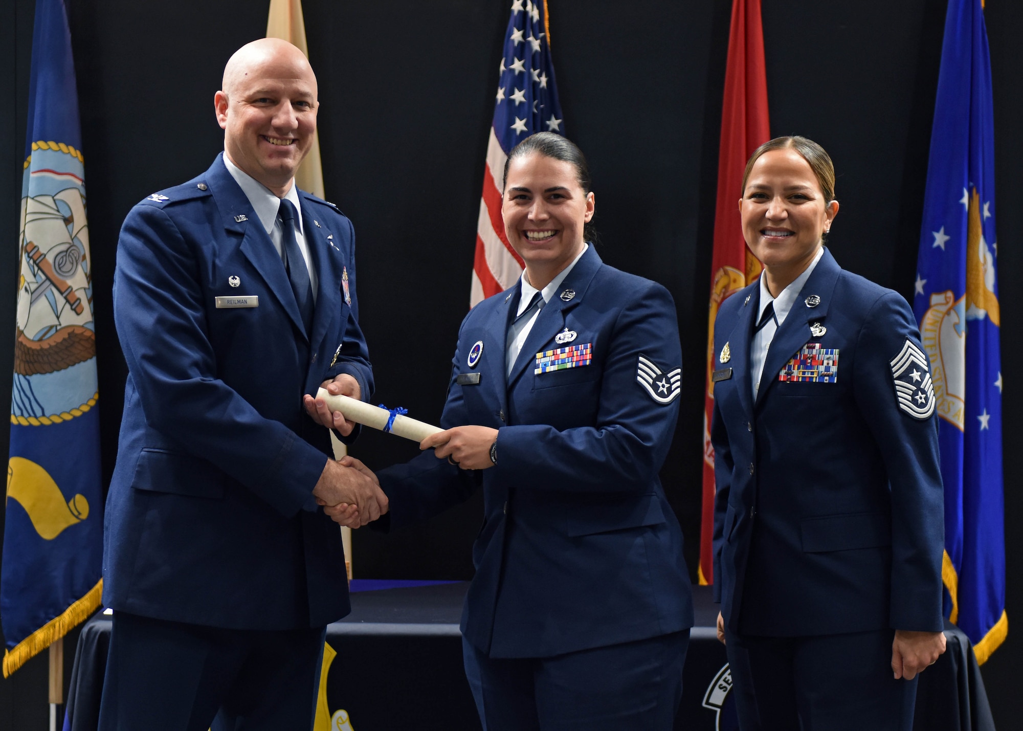 U.S. Air Force Col. Matthew Reilman, 17th Training Wing commander, presents Staff Sgt. Patricia Denman, 315th Training Squadron instructor, with a diploma from the Community College of the Air Force at the CCAF graduation in the Powell Event Center, Goodfellow Air Force Base, Texas, Nov. 16, 2022. The 54 graduates gained their associate degree through hard work and dedication. (U.S. Air Force photo by Airman 1st Class Sarah Williams)