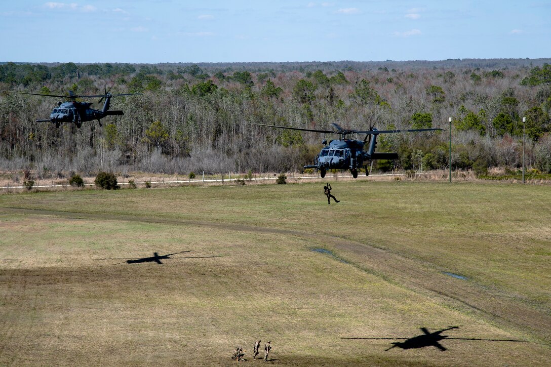 Photo of two helicopters hovering over land