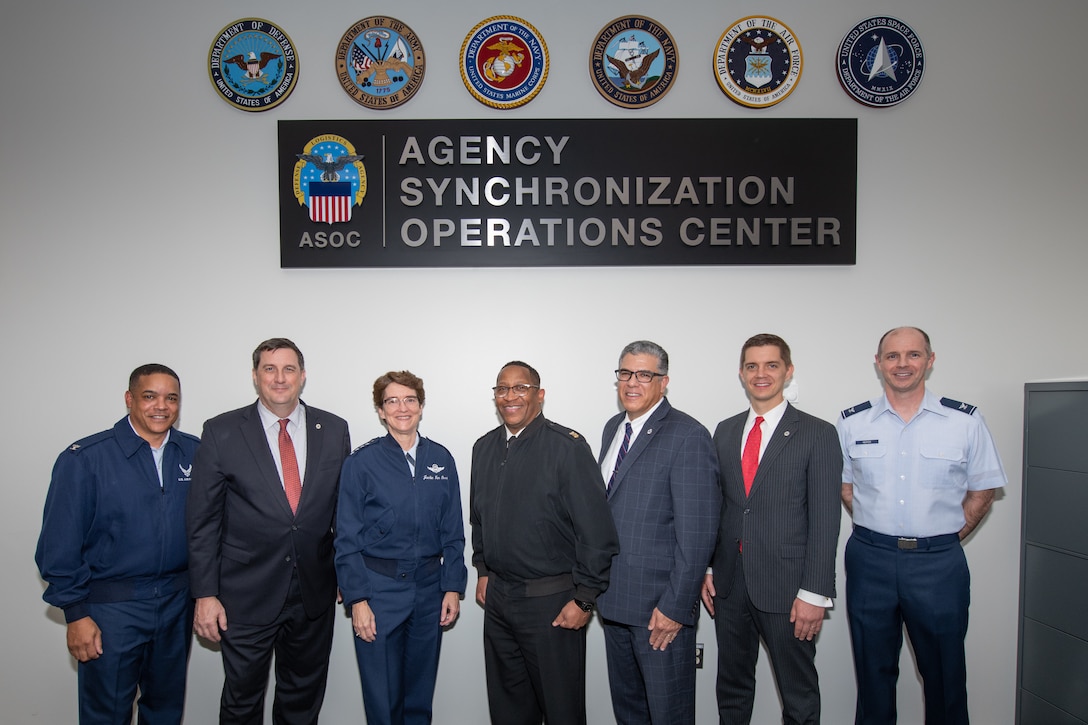 A group of military and civilian personnel pose for a group photo.