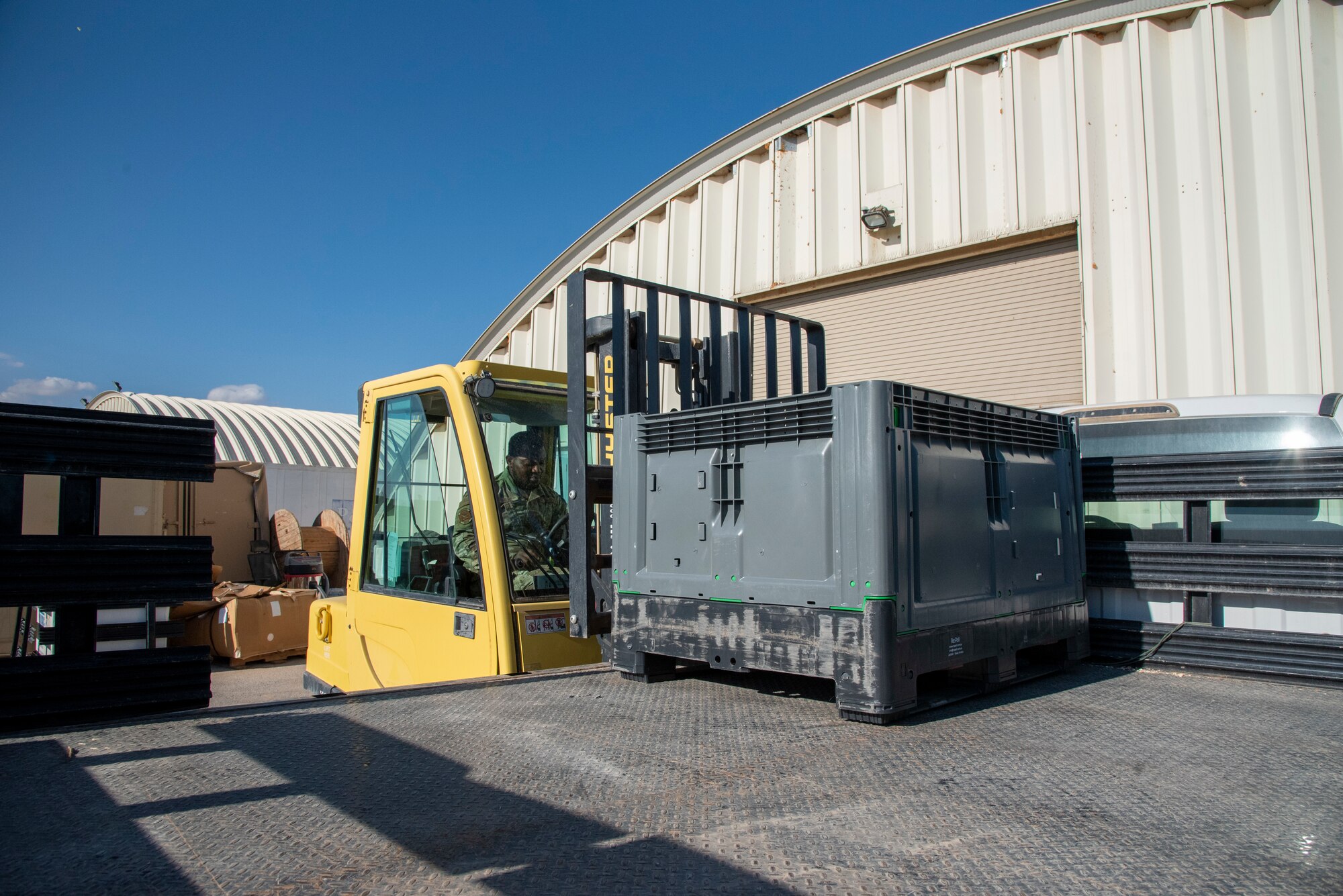 Senior Airman Joseph Essilfie, 332d Expeditionary Logistics Readiness Squadron Individual Protective Equipment personnel, operates a forklift to place a crate of ballistic plates on a truck at an undisclosed location, Southwest Asia, Nov. 11, 2022. These plates must be regularly shipped to testing facilities to ensure their structural integrity and continued effectiveness in body armor. (U.S. Air Force photo by: Tech. Sgt. Jim Bentley)