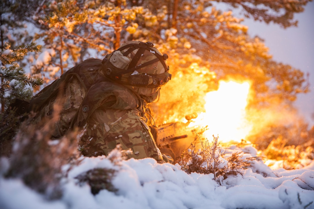 A soldier holds a weapon and fires during a training exercise.