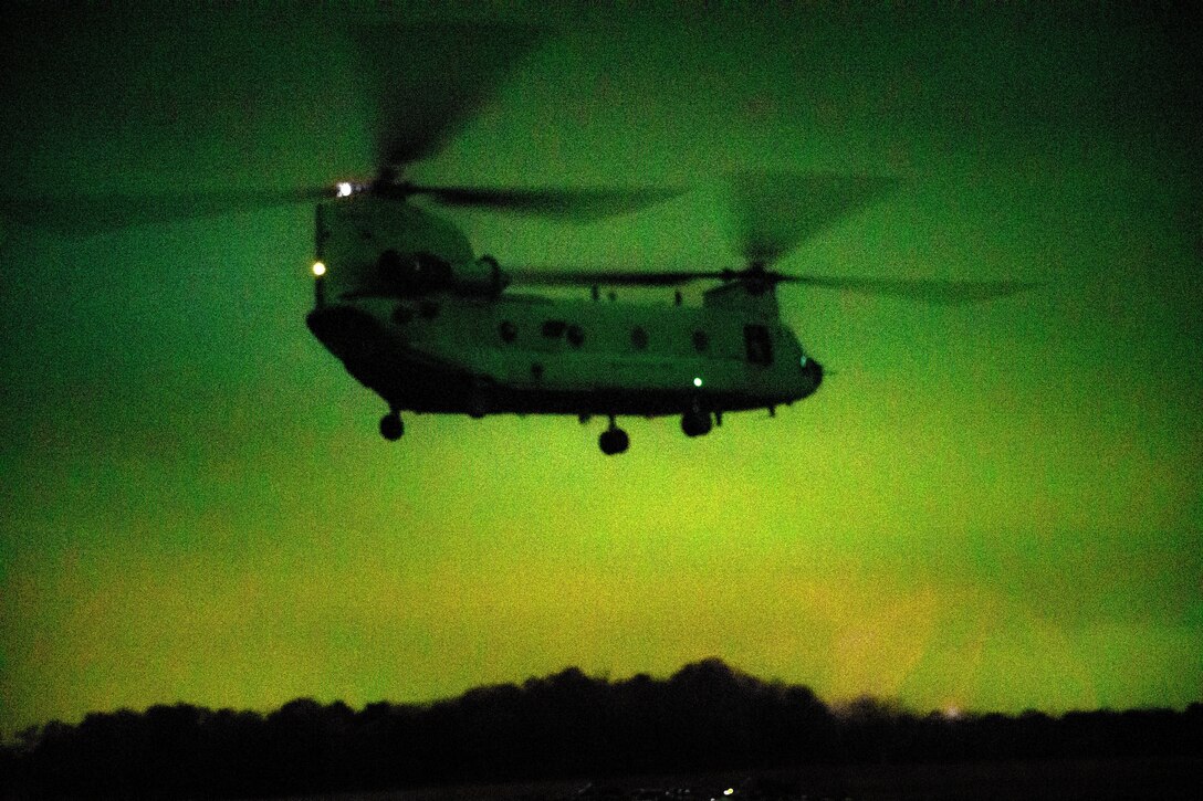 A helicopter lands during a night training exercise.