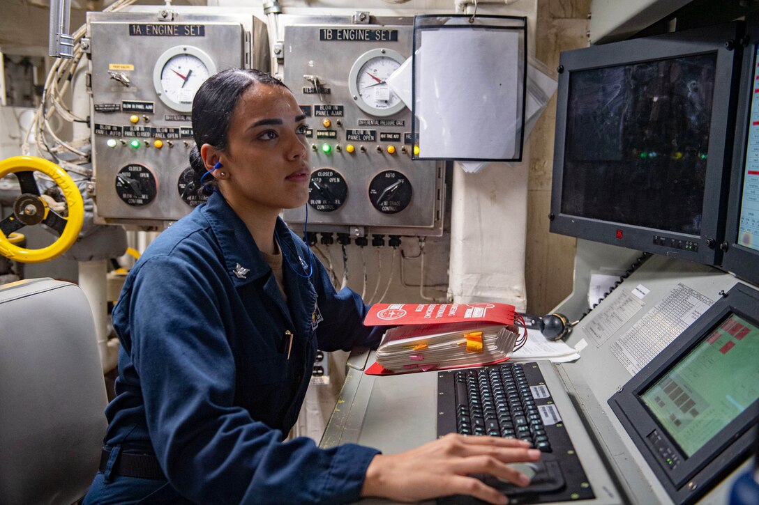 A sailor operates a computer.