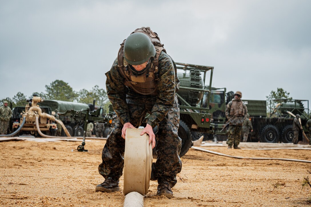 Pfc. Khalil Wakeem a bulk fuel specialist with 6th Engineer Support Battalion Company B, 4th Marine Logistics Group, rolls up a hose at Joint Base McGuire-Dix-Lakehurst, New Jersey, Mar. 12, 2022. 6th ESB focuses on innovating and experimenting on Expeditionary Advanced Base Operations. This training covers an innovative, new, and unique expeditionary fueling dispensing system to increase the unit's effectiveness and mission readiness. Marines from 6th ESB have proven their ingenuity by creating a smaller and more agile fueling capability from a much larger legacy fueling system.  Their innovative efforts consist of swiftly staging low profile fueling points in order to allow forces the flexibility to flow quickly in and out of enemy engagement zones.