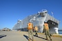 Sailors from Navy Cargo Handling Battalion 1 (NCHB 1) prepare to receive shot lines as the Military Sealift Command joint high-speed vessel USNS Choctaw County (JHSV 2) prepares to moor pier side Cheatham Annex.