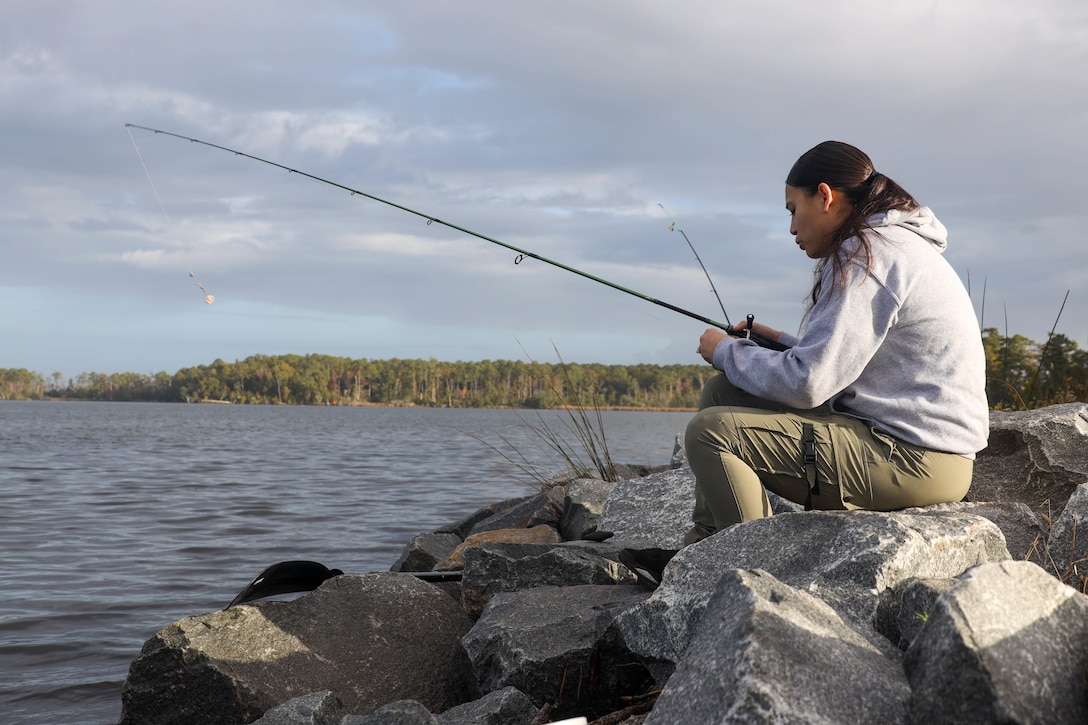 U.S. Marine Corps Cpl. Monic Hernandez, a food service Marine with Headquarters and Headquarters Squadron, Marine Corps Air Station (MCAS) Cherry Point, fishes on the shoreline during the "Get Reel About Prevention" fishing tournament, Hancock Marina, MCAS Cherry Point, North Carolina, Nov. 4, 2022. The tournament allowed U.S. Marines, their families, and air station civilians the opportunity to gather for a fun, collective competition and learn more about various violence prevention resources. (U.S. Marine Corps photos by Lance Cpl. Tristen Reed)