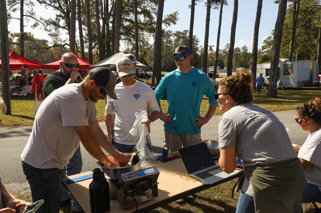 Marine Corps Community Services employees measure a competitor's fish as part of the "Get Reel About Prevention" fishing tournament, Hancock Marina, Marine Corps Air Station Cherry Point, North Carolina, Nov. 04, 2022. The tournament allowed U.S. Marines, their families, and air station civilians the opportunity to gather for a fun, collective competition and learn more about various violence prevention resources. (U.S. Marine Corps photos by Lance Cpl. Tristen Reed)