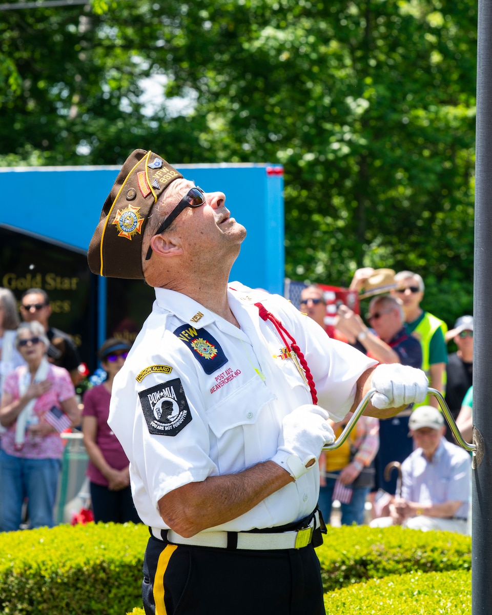 Honor guard member raises the flag.