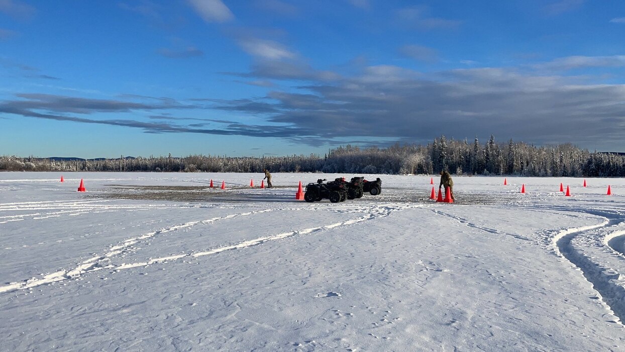 Airmen hike a trail using snowshoes