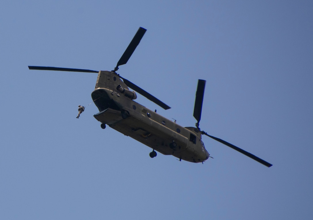 An Airmen from the 14th Air Support Operations Squadron jumps from a Pennsylvania Army National Guard CH-47 Chinook during airborne operations at Fort Indiantown Gap, Pa. The pilots and crew chiefs of the chinook worked to provide the Airmen with a stable platform as they moved over the drop area