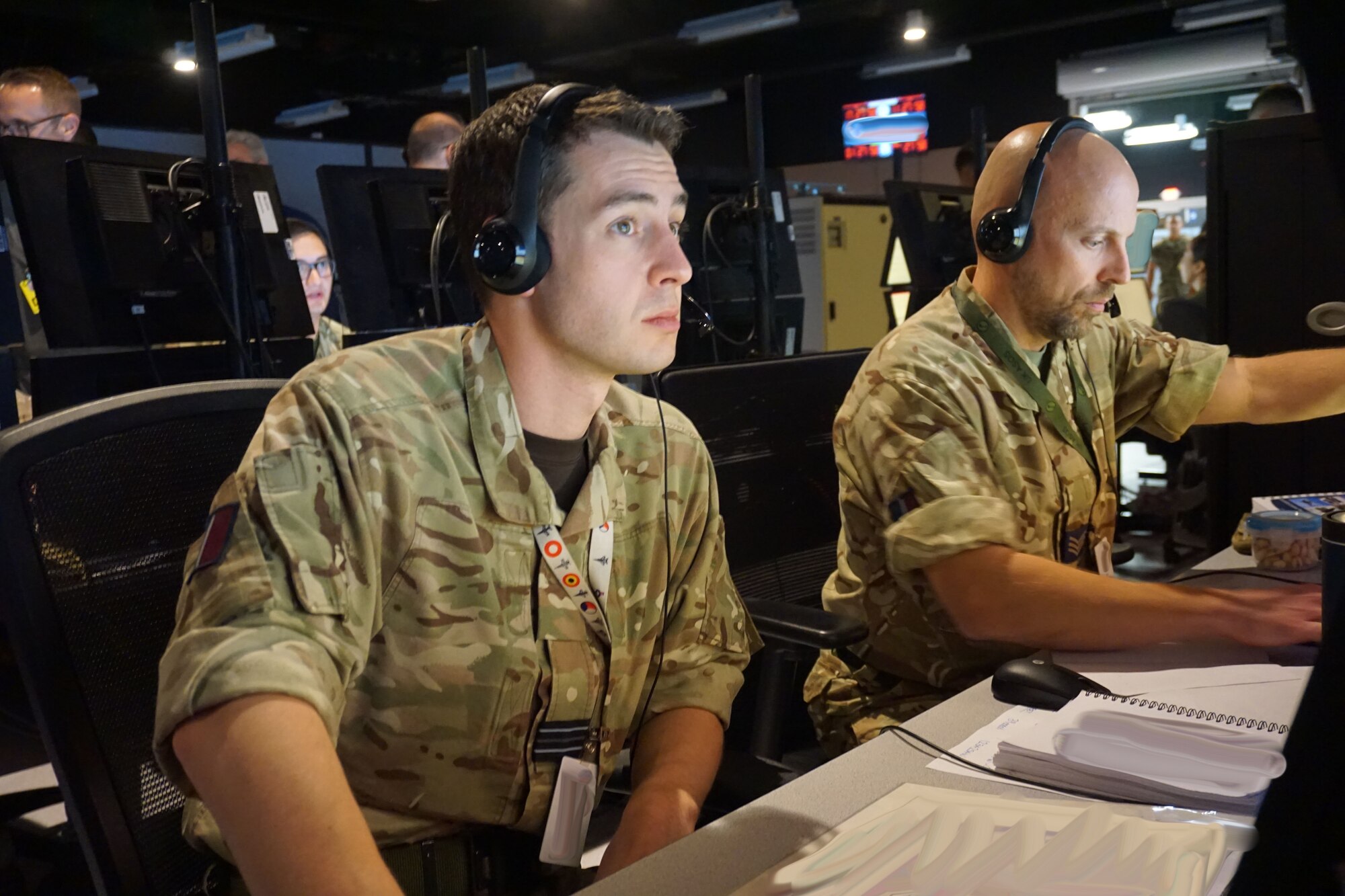 military members sit working at computers