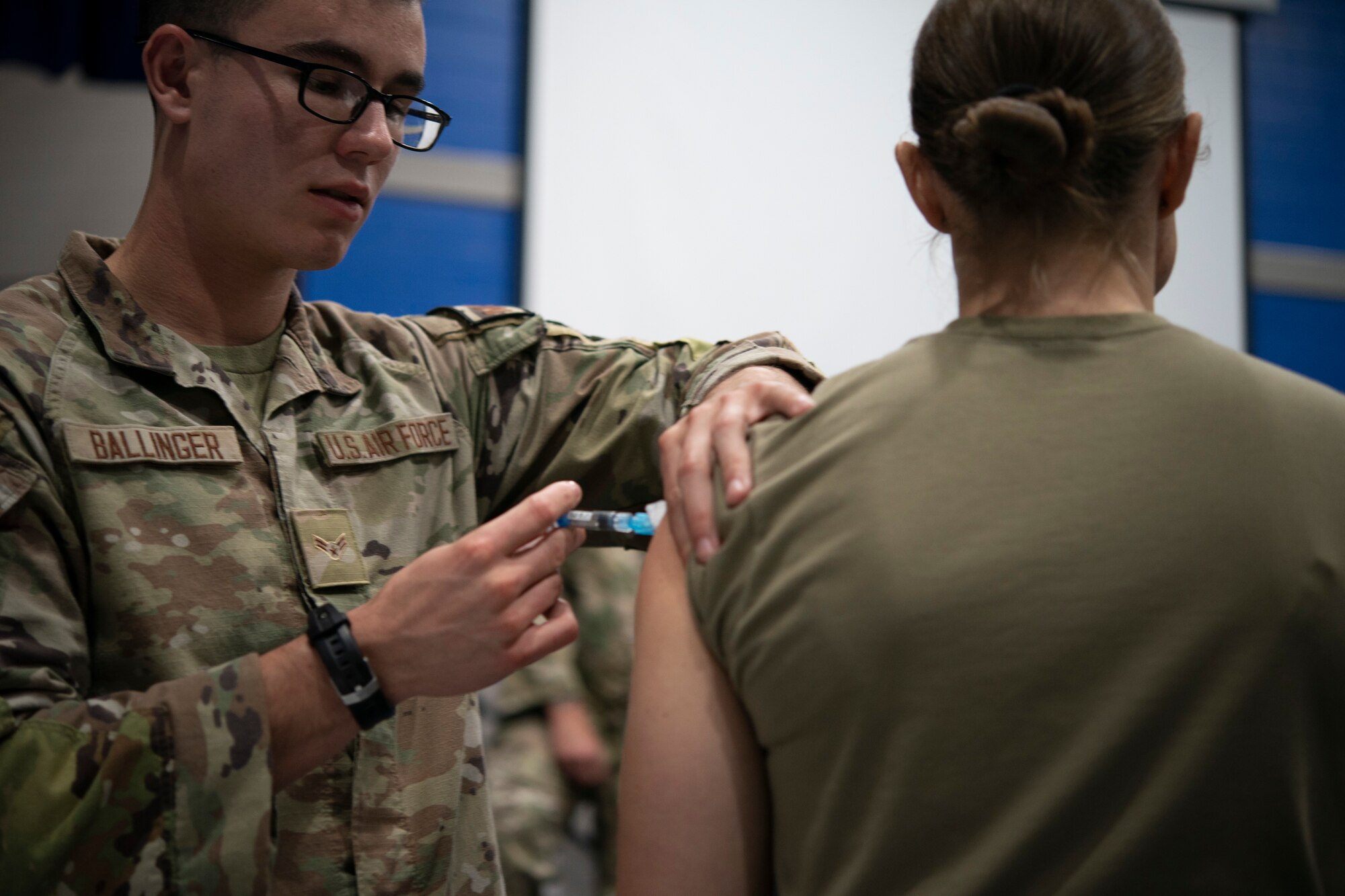 Photo of Airman giving another Airman shot.