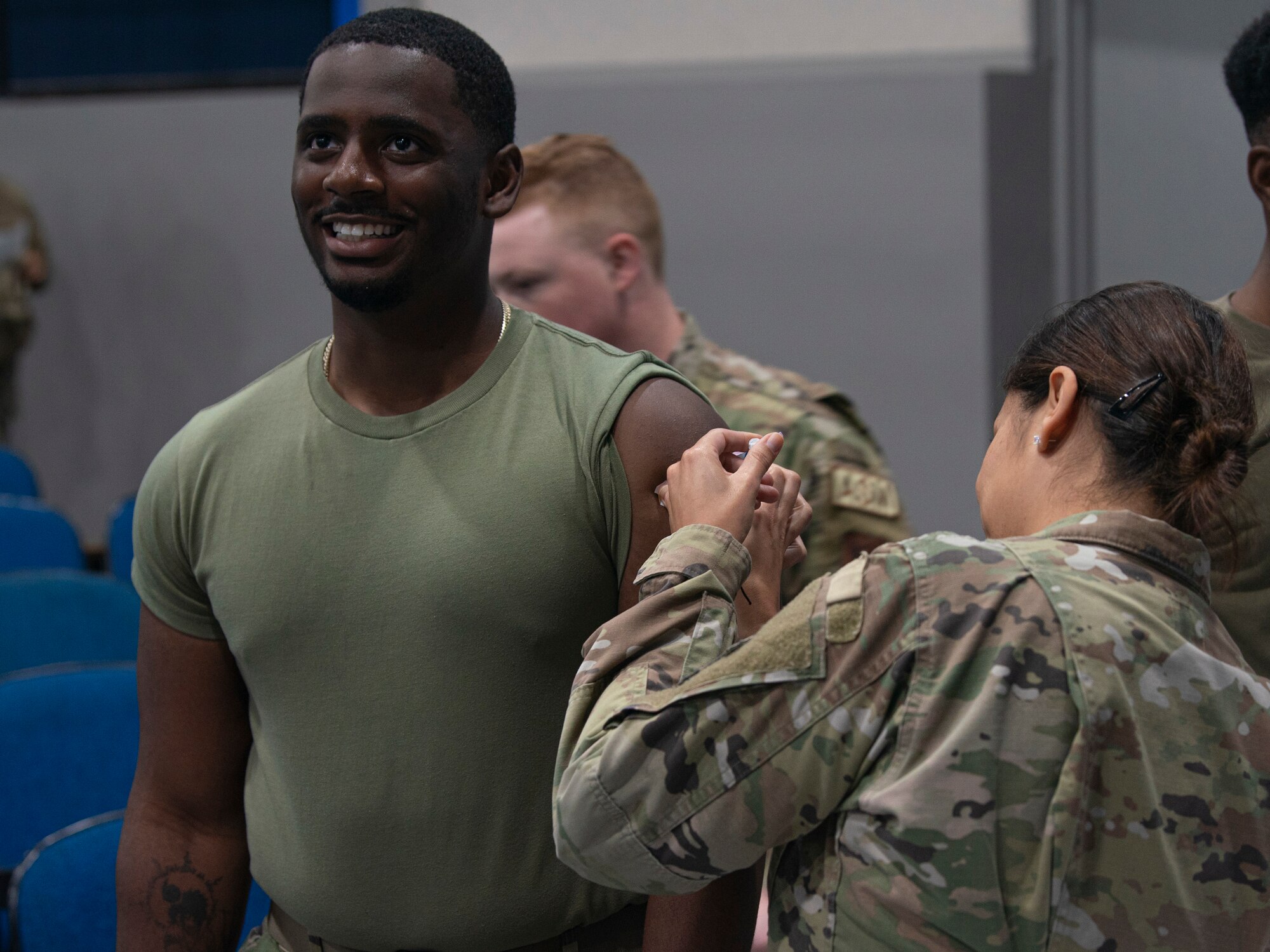 Photo of Airman giving another Airman a vaccine.