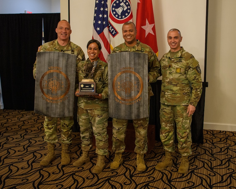 men and women wearing u.s. army uniforms standing in front of flags.