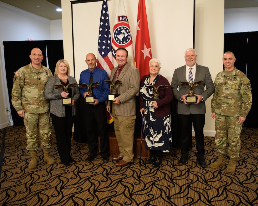 men and women wearing u.s. army uniforms standing in front of flags.