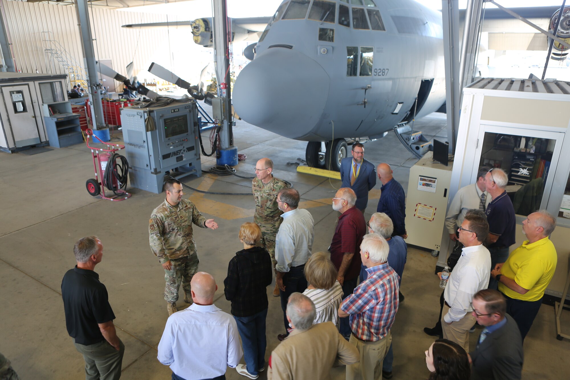 U.S. Air Force Gen. Duke Z. Richardson, commander of Air Force Materiel Command, (top center) and AFMC Civic Leaders stand and listen to a quick briefing at the maintenance shelter.