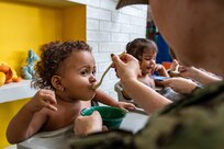 221116-N-LP924-1170 CARTAGENA, Colombia (Nov. 16, 2022) Cmdr. Angela Roldan-Whitaker, from Bogota, Colombia, assigned to the hospital ship USNS Comfort (T-AH 20), feeds a child during a Women’s, Peace and Security (WPS) event with free medical care as part of Continuing Promise 2022 at Juan Fe, in Cartagena, Colombia, Nov. 16, 2022. Comfort is deployed to U.S. 4th Fleet in support of Continuing Promise 2022, a humanitarian assistance and goodwill mission conducting direct medical care, expeditionary veterinary care, and subject matter expert exchanges with five partner nations in the Caribbean, Central and South America. (U.S. Navy photo by Mass Communication Specialist 3rd Class Sophia Simons)
