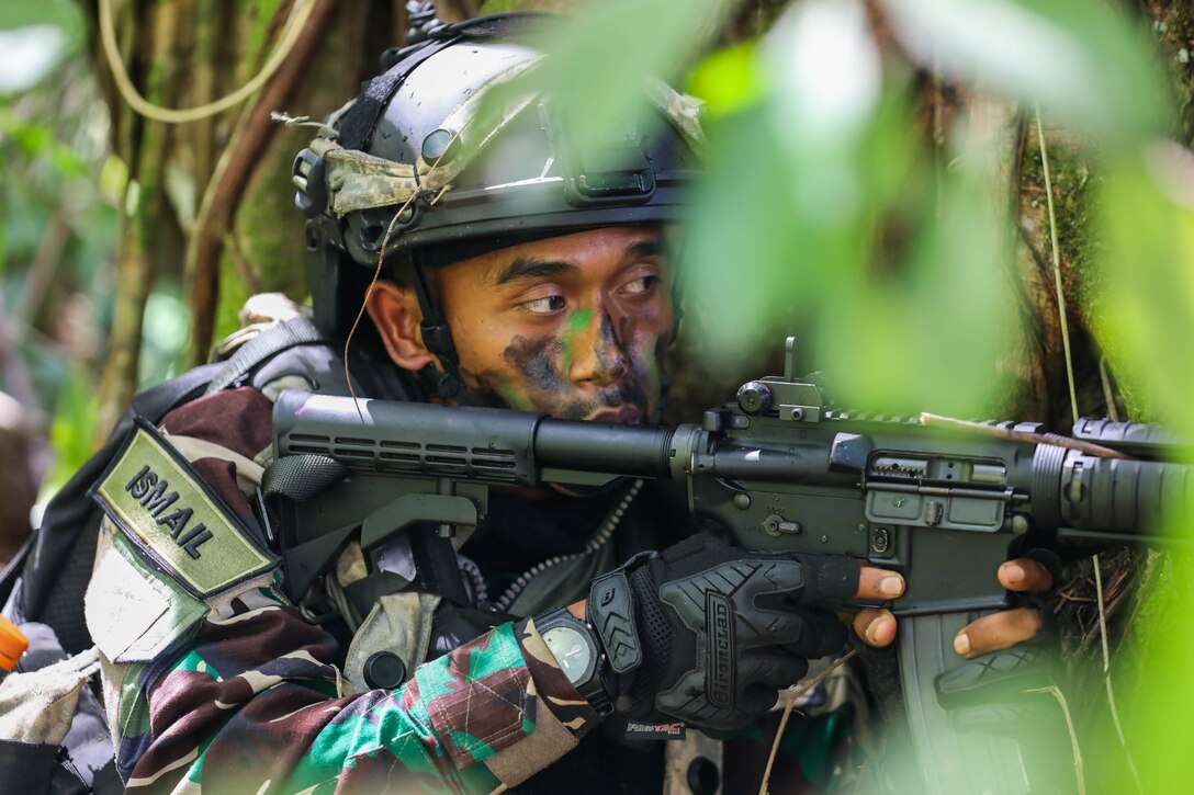 A Soldier from the Indonesian National Army scans for opposing forces during the Joint Pacific Multi-National Rotation Center rotation 22-01 exercise on Oct. 25, 2021 at Kahuku Training Area, Hawaii. JPMRC Rotation 22-01 provides the 25th ID the opportunity to integrate and train alongside our partners and allies throughout the Indo-Pacific Region.