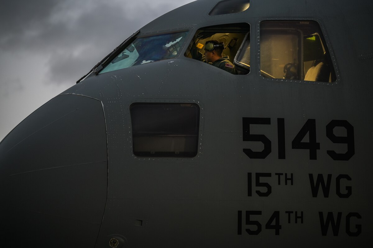 Staff Sgt. Pono Daite, 154th Aircraft Maintenance Squadron crew chief, performs a pre-flight check inside a C-17 Globemaster III flight deck at Joint Base Pearl Harbor-Hickam, Hawaii, Nov. 12, 2022. Exercise Global Dexterity 2022 is being conducted at RAAF Base Amberley, and is designed to help develop the bilateral tactical airlift and airdrop capabilities of the United States Air Force (USAF) and the Royal Australian Air Force (RAAF). Both the United States and Australia rely on the C-17A to provide strategic and tactical airlift across the Indo-Pacific region, with its ability to provide short-notice and time-critical airlift support making it essential during humanitarian assistance and disaster relief operations. (U.S. Air Force photo by Staff Sgt. Alan Ricker)