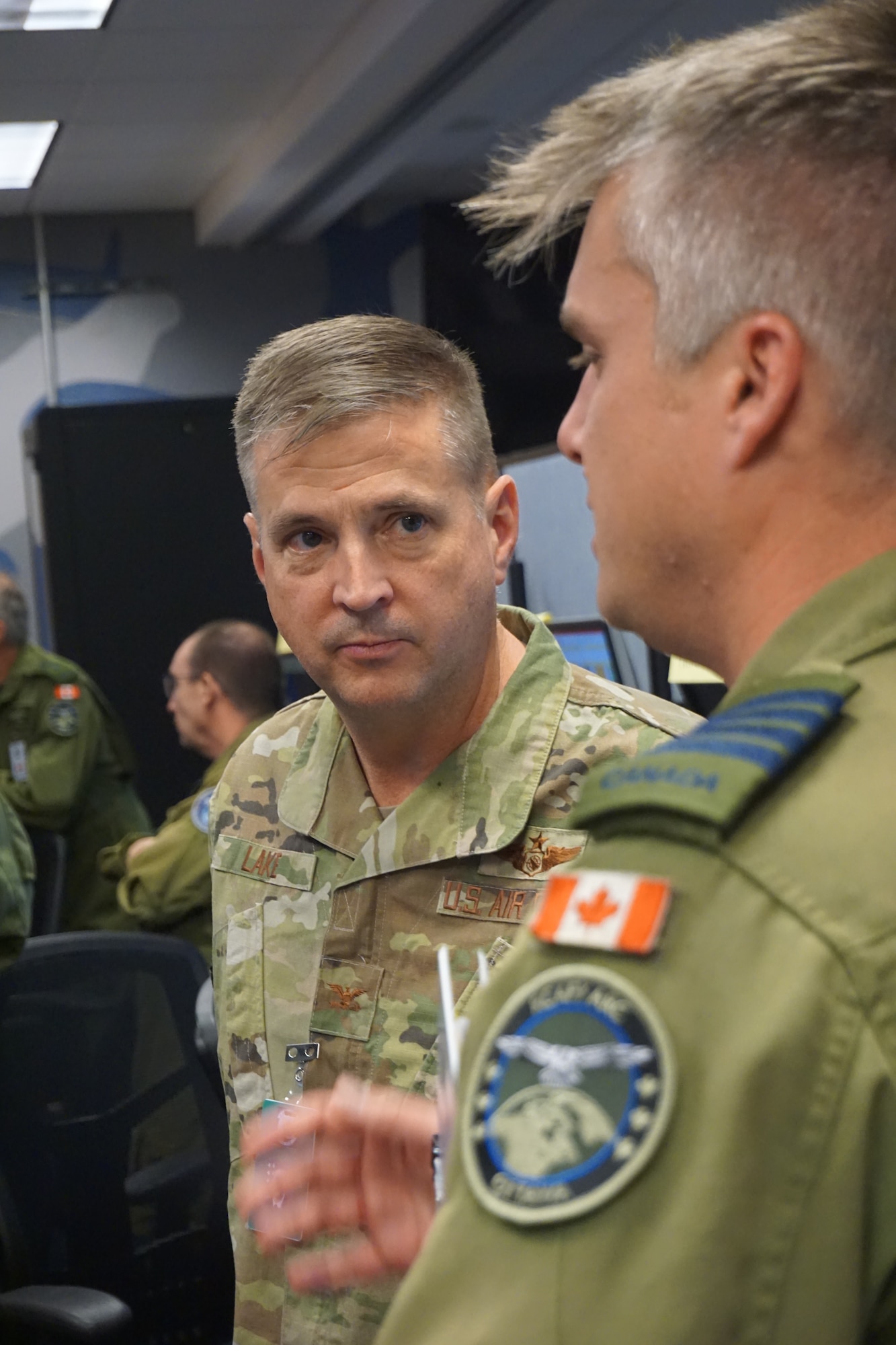 two military members standing talking to each other in an office environment