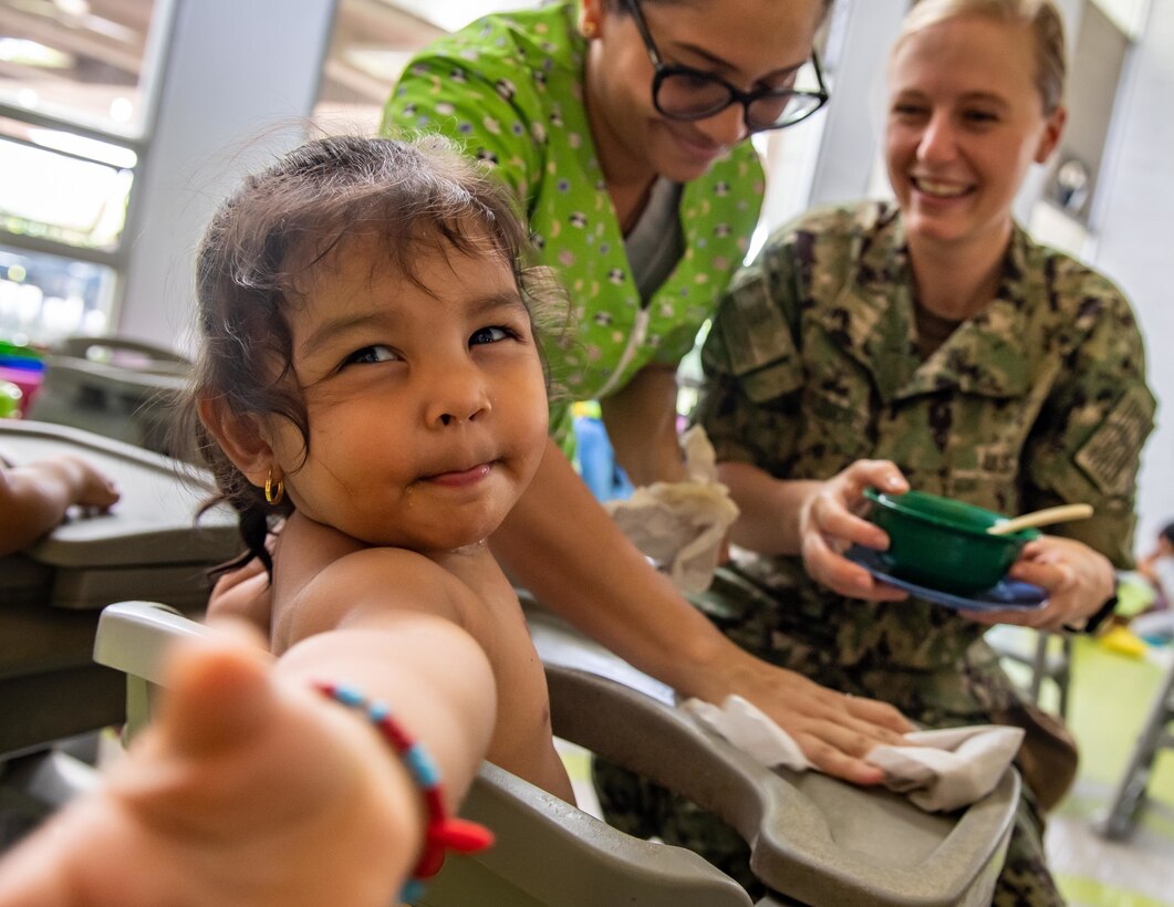 221116-N-LP924-1160 CARTAGENA, Colombia (Nov. 16, 2022) Lt. Lindsey Grzegorzewski, from Cincinnati, Ohio, assigned to the hospital ship USNS Comfort (T-AH 20), feeds a child during a Women’s, Peace and Security (WPS) event with free medical care as part of Continuing Promise 2022 at Juan Fe, in Cartagena, Colombia, Nov. 16, 2022. Comfort is deployed to U.S. 4th Fleet in support of Continuing Promise 2022, a humanitarian assistance and goodwill mission conducting direct medical care, expeditionary veterinary care, and subject matter expert exchanges with five partner nations in the Caribbean, Central and South America. (U.S. Navy photo by Mass Communication Specialist 3rd Class Sophia Simons)