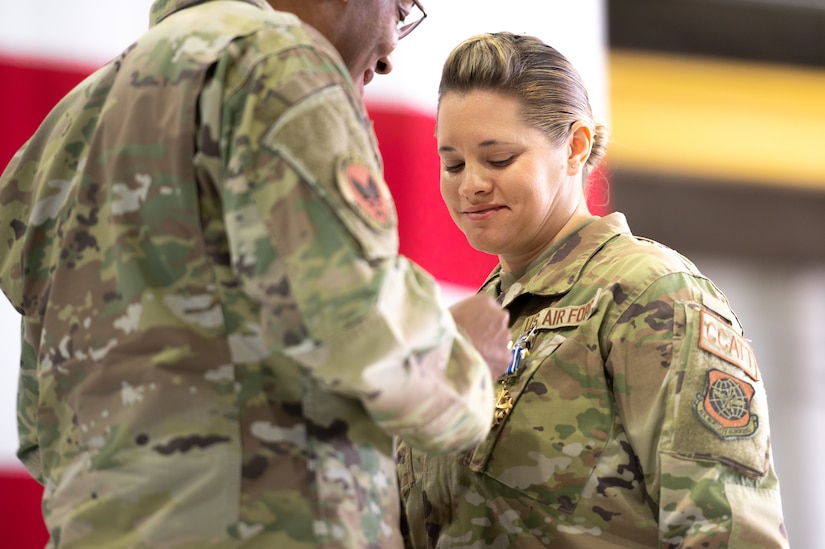 An Air Force leader pins a medal on an airman's uniform.