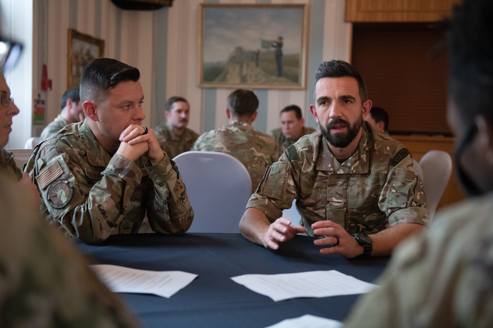 U.S. and Royal Air Force personnel talk during a leadership collaboration event Nov. 10, 2022, at RAF Honington, England. The goal of the event was to give noncommissioned officers from both nations the opportunity to share knowledge and experiences as well as strengthening bonds between the partner nations. (U.S. Air Force photo by Staff Sgt. Charles Welty)