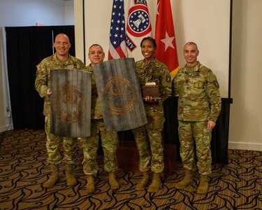 men and women wearing u.s. army uniforms standing in front of flags.