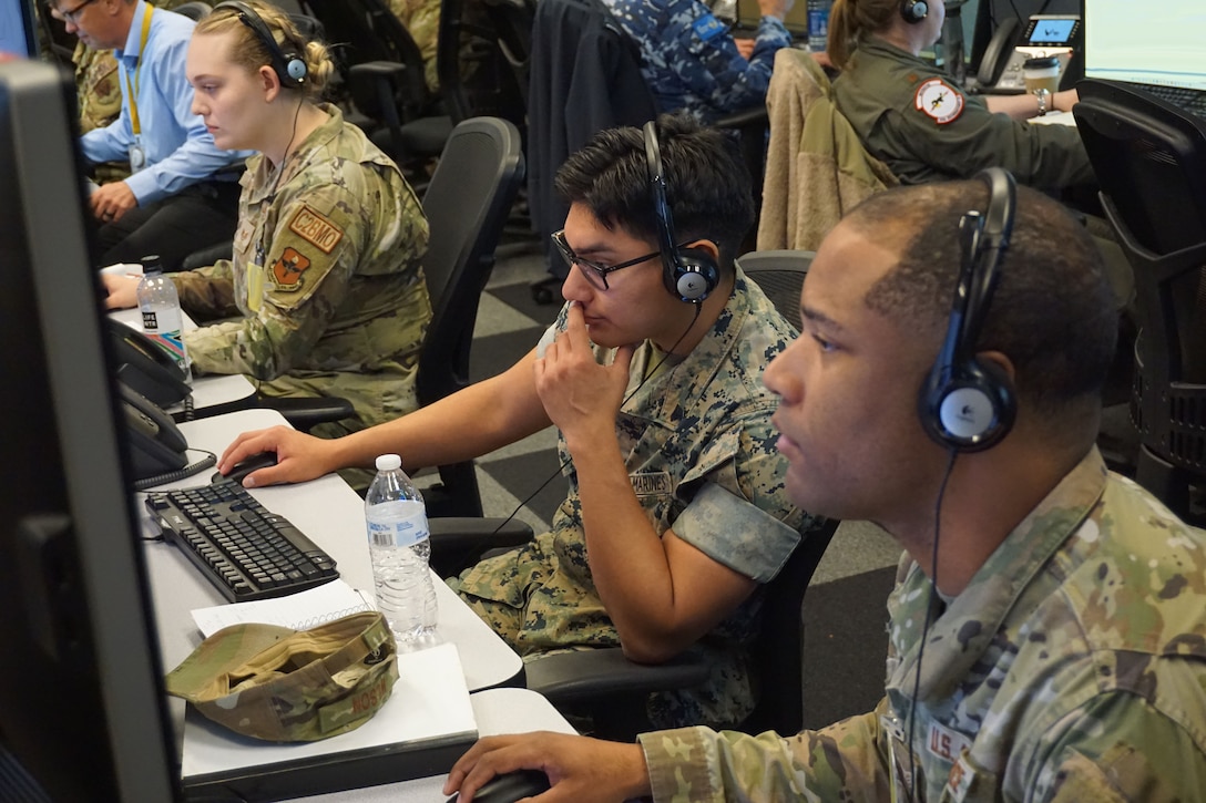 U.S. Marine Corps and U.S. Air Force forces participating in VIRTUAL FLAG: Coalition 23-1 in the Air Operations Center at the 705th Combat Training Squadron, also known as the Distributed Mission Operations Center, at Kirtland Air Force Base, New Mexico, and distributed sites across four countries, Oct. 24 – Nov. 4, 2022. Exercise VFC serves as a train as you fight exercise by integrating the full spectrum of air, land, surface, space, and cyber warfighters in a virtual battlespace in joint and coalition environments; forces from the United States, United Kingdom, Australia, and Canada participated. (Computer screens and security badges were blurred for security purposes. (U.S. Air Force photo by Ms. Deb Henley)