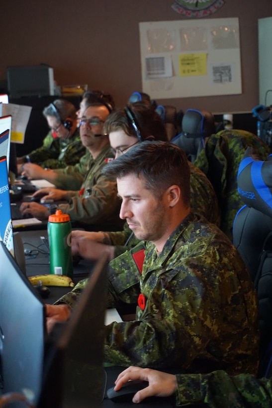 Royal Canadian forces participating in VIRTUAL FLAG: Coalition 23-1 at the 705th Combat Training Squadron, also known as the Distributed Mission Operations Center, at Kirtland Air Force Base, New Mexico, and distributed sites across four countries, Oct. 24 – Nov. 4, 2022. Exercise VFC serves as a train as you fight exercise by integrating the full spectrum of air, land, surface, space, and cyber warfighters in a virtual battlespace in joint and coalition environments; forces from the United States, United Kingdom, Australia, and Canada participated. (Security badges and computer screens were blurred for security purposes.) (U.S. Air Force photo by Ms. Deb Henley)