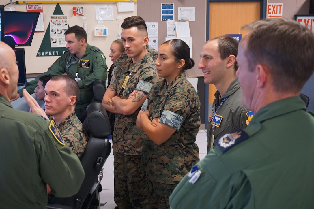 Royal Air Force MQ-9 pilot discusses training with U.S. Air Force and U.S. Marine Corps forces during VIRTUAL FLAG: Coalition 23-1 to help deter enemy forces while allowing the U.S. Navy freedom of maneuver at Kirtland Air Force Base, New Mexico, Oct. 28, 2022.  The 705th Combat Training Squadron, also known as the Distributed Mission Operations Center, executes exercise VFC as a train as you fight exercise by integrating the full spectrum of air, land, surface, space, and cyber warfighters in a virtual battlespace in joint and coalition environments; forces from the United States, United Kingdom, Australia, and Canada participated. (Security badges and computer screens were blurred for security purposes) (U.S. Air Force photo by Ms. Deb Henley)