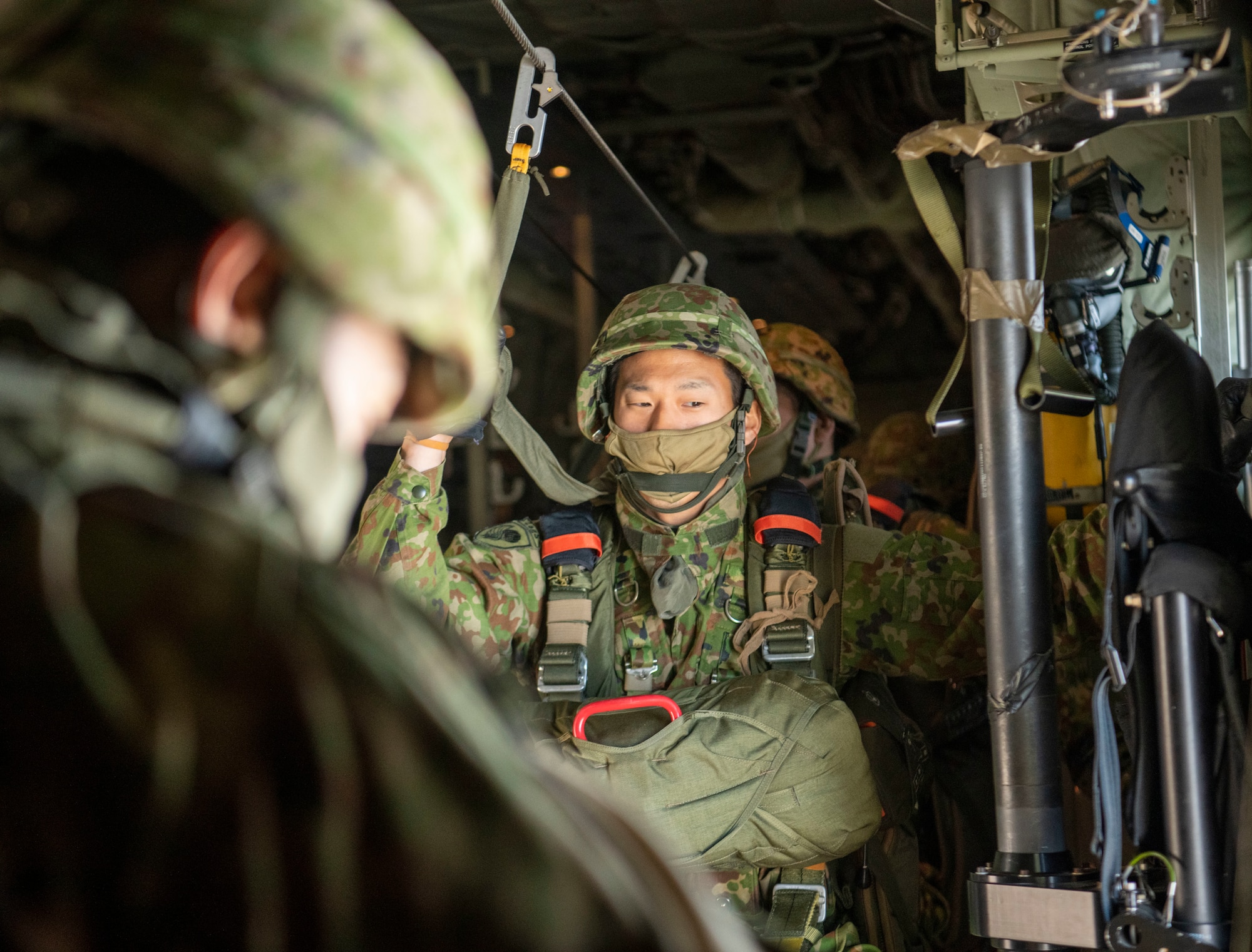 A Japan Ground Self-Defense Force paratrooper assigned to the 1st Airborne Brigade stares out of the open paratroop door before static line jumps over Narashino drop zone, Chiba, Japan, Nov. 10, 2022