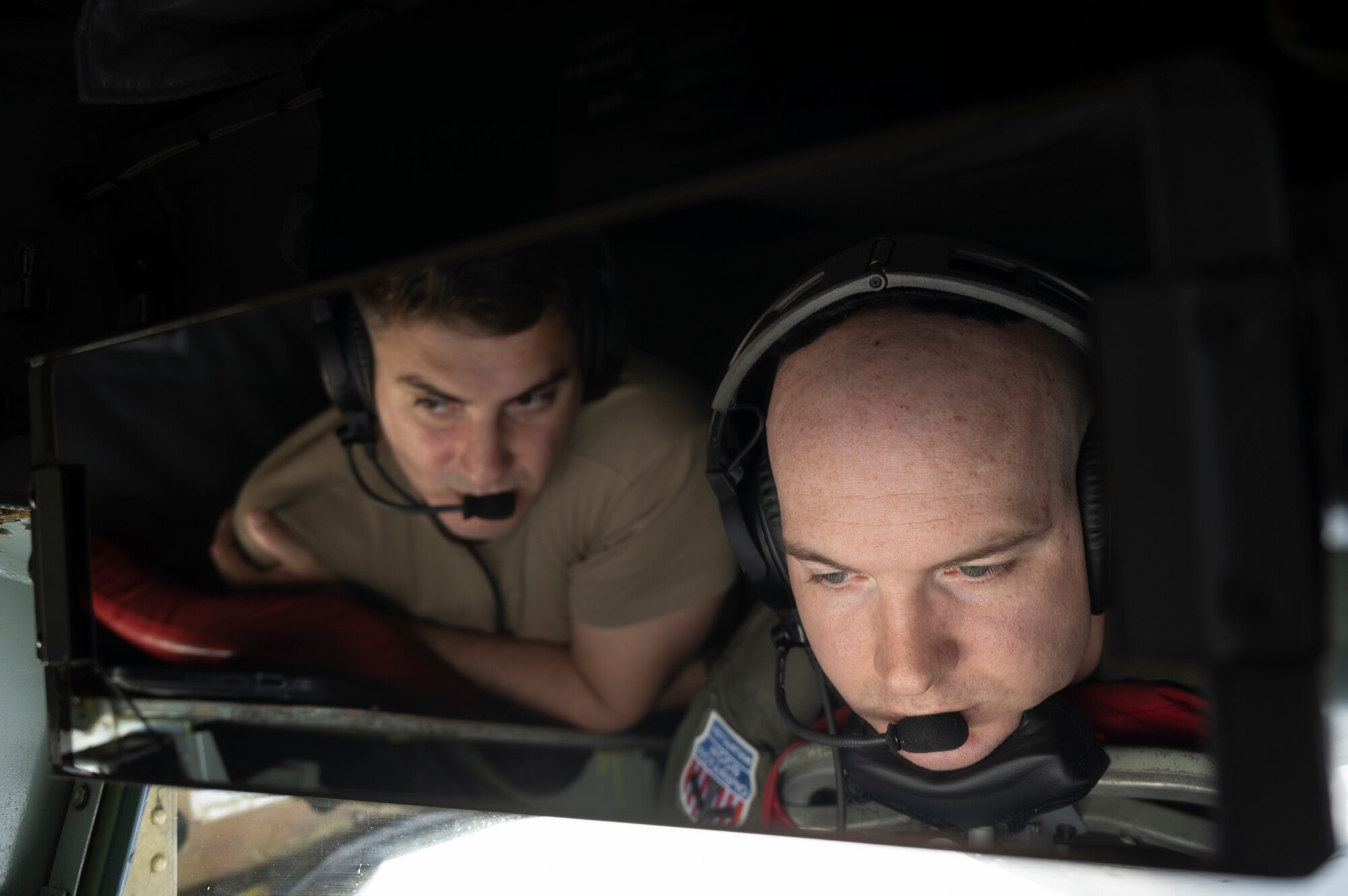 Tech Sgt. Lucas Balcarce, 909th Air Refueling Squadron boom operator, observes as SSgt. Andrew Chase, 909th ARS boom operator, delivers fuel to an F-15C Eagle during a flight over the Pacific Ocean in support of exercise Keen Sword 23, Nov. 17, 2022. Joint and bilateral cooperation and collaboration enhance regional security, stability, and prosperity. (U.S. Air Force photo by Senior Airman Jessi Roth)