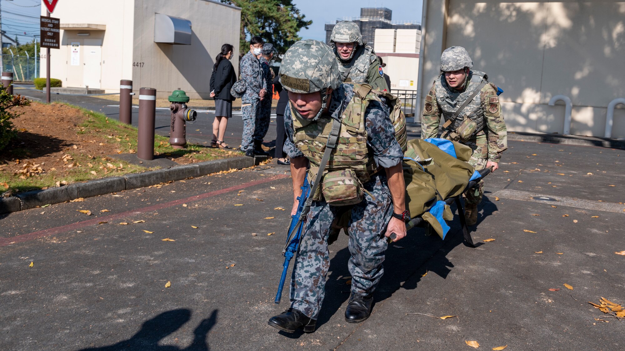 A team of combat medics carry a stretcher to a safe zone