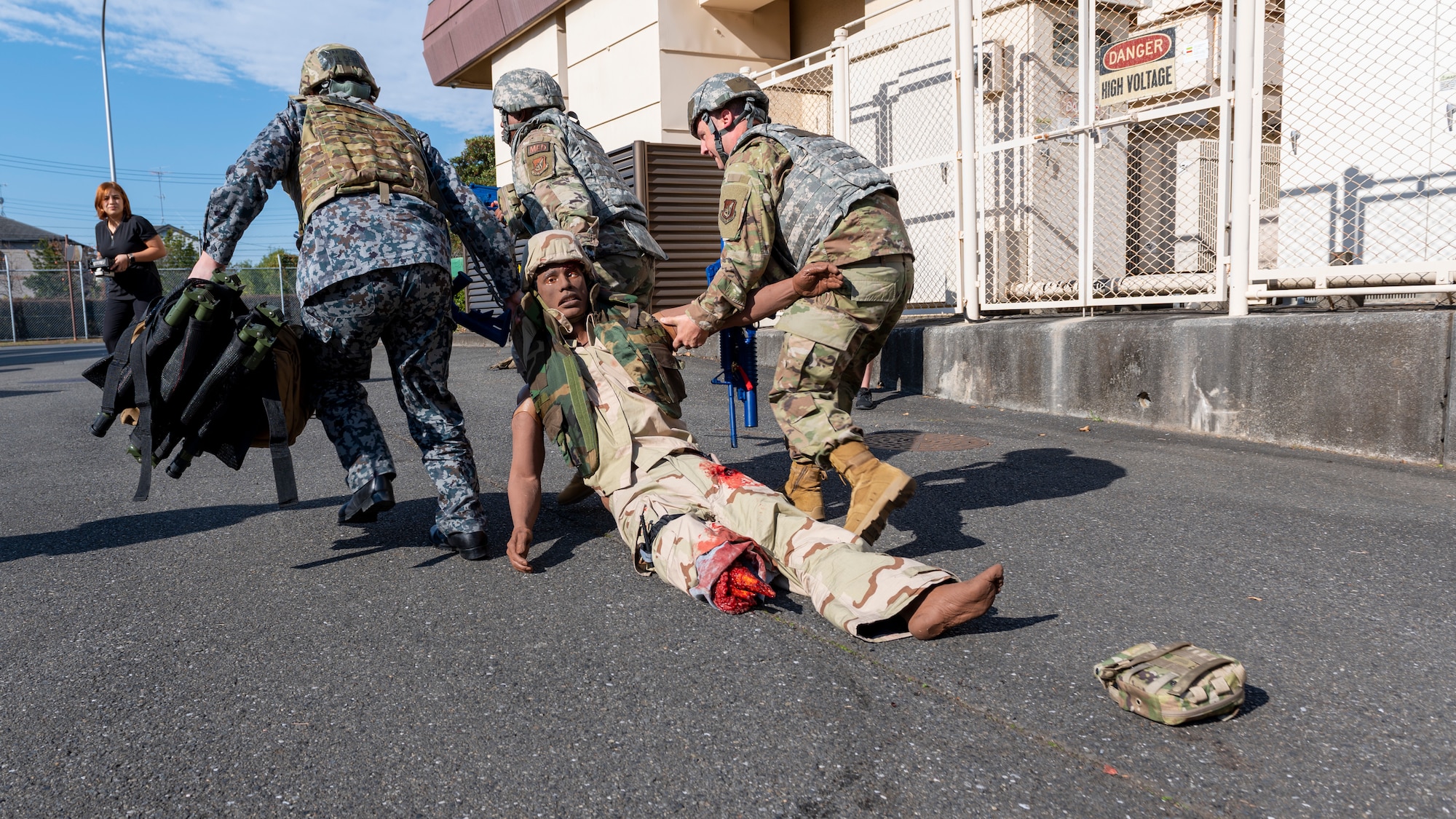 Three medical Airmen drag a medical training dummy to safety