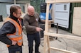 Antony Phoenix (right), the preservation team lead at Zutendaal Army Prepositioned Stocks-2 worksite, discusses a work project with one of his team members, carpenter Jurgen Van Hees. Phoenix is responsible for a team of six personnel, to include a carpenter. Their mission is to ensure all APS-2 equipment is preserved properly, in accordance with Army guidelines and regulations. (U.S. Army courtesy photo)