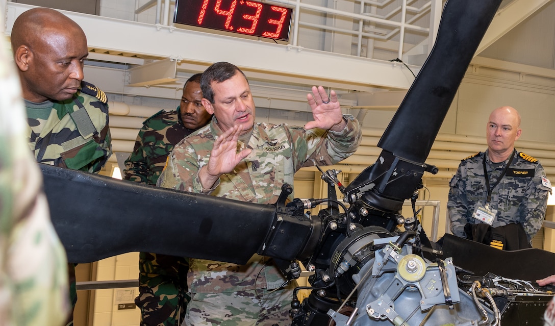 First Sgt. Steven Shirk, with the Eastern Army National Guard Aviation Training Site explains to a group of vising foreign military officers how advanced the Uk-H60 Blackhawk training devices here provide realistic training for aviation maintainers Nov. 16 during Defense Intelligence Agency’s Fall 2022 Operations Orientation Program tour of Pennsylvania National Guard facilities here.