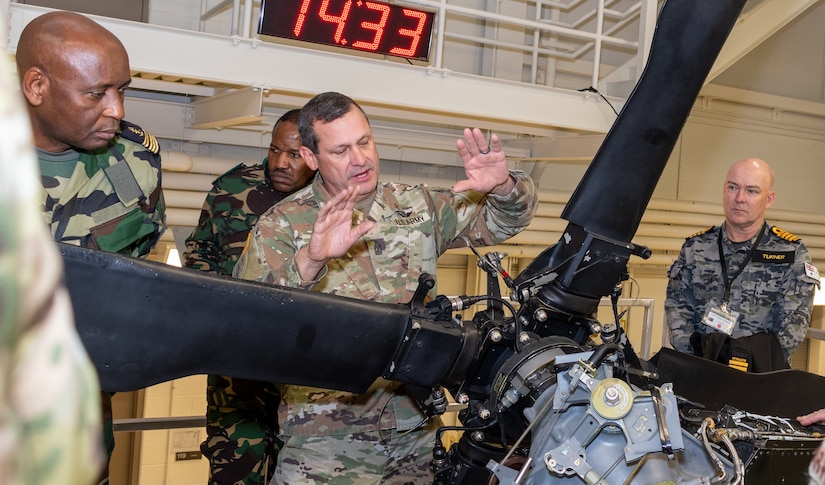 First Sgt. Steven Shirk, with the Eastern Army National Guard Aviation Training Site explains to a group of vising foreign military officers how advanced the Uk-H60 Blackhawk training devices here provide realistic training for aviation maintainers Nov. 16 during Defense Intelligence Agency’s Fall 2022 Operations Orientation Program tour of Pennsylvania National Guard facilities here.