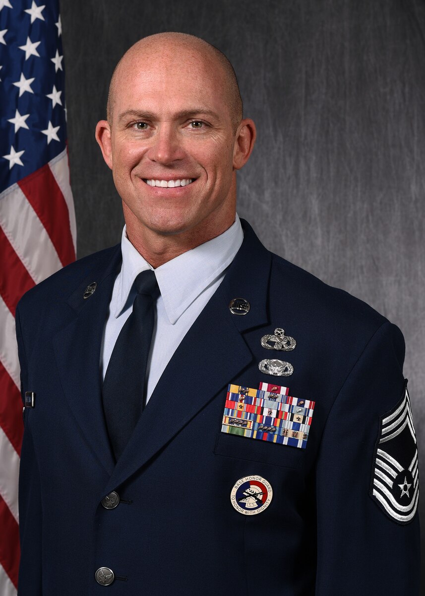 Chief Master Sgt. Dennis G. Jendrzejewski poses for a photo in front of a gray background