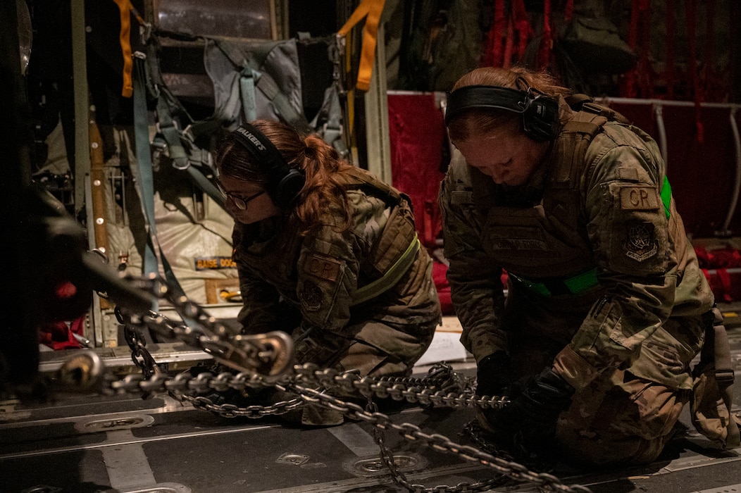 Airmen secure cargo onto a C-130J Super Hercules