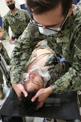 Hospital Corpsman 3rd Class Juan Lopez, Expeditionary Medical Facility 150-Alpha (EMF150-A), out of Camp Pendleton, California, evaluates simulated casualty Hospital Corpsman 3rd Class Louis Grass, EMF 150-A, in the EMF at Camp Foster, Marine Corps Base S.D. Butler, Okinawa prefecture, Japan, during exercise Keen Sword 23, Nov. 15. Keen Sword is a joint, bilateral, biennial field-training exercise involving U.S. military and Japan Self-Defense Force personnel, designed to increase combat readiness and interoperability and strengthen the ironclad Japan-U.S. alliance. (Courtesy photo/Released)