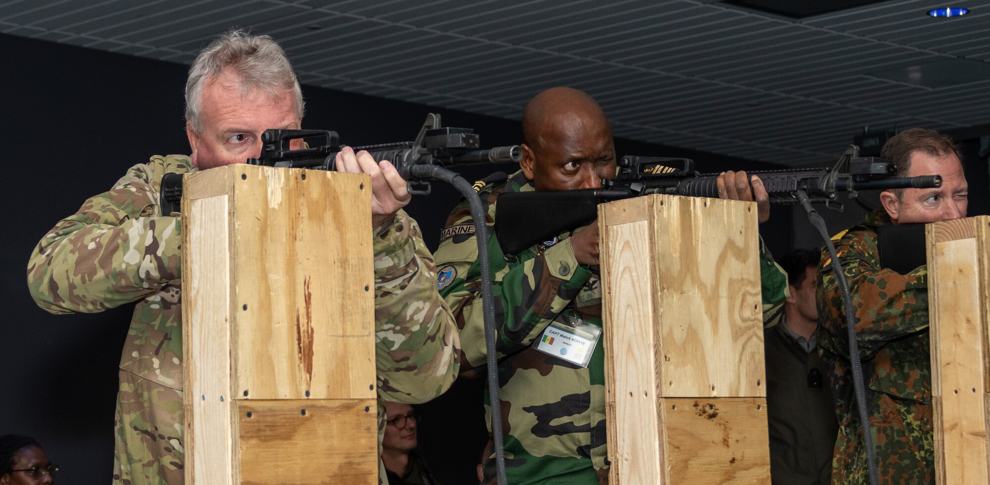 Defense attachés Brig. Gen. Michael Shapland of New Zealand, Capt. Malick Ndiaye of Senegal, and Rear Adm. Axel Ristau of Germany fire at targets on a range simulator at Fort Indiantown Gap’s Training Support Center Nov. 16, 2022, during the Defense Intelligence Agency’s Fall 2022 Operations Orientation Program tour of Pennsylvania National Guard facilities.