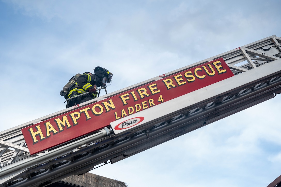 Casey Patrick, Hampton Division of Fire and Rescue EMT firefighter, ascends Ladder 4 to reach the third-floor window of the burning building during a rapid intervention team work exercise at Joint Base Langley-Eustis, Virginia, Nov. 17, 2022.