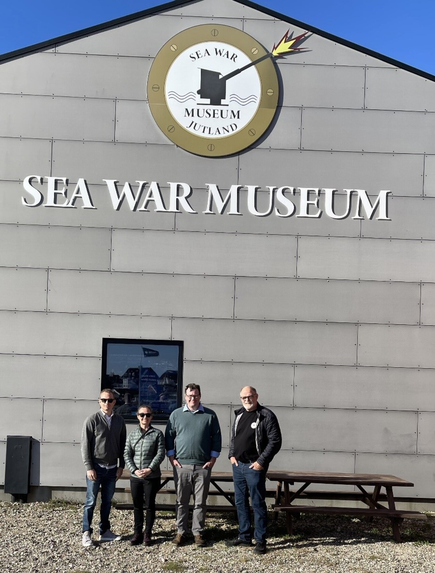 Four DPAA team members standing in front of the Sea War Museum