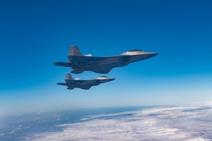 U.S. Air Force F-22A Raptors assigned to the 3rd Wing, fly alongside a KC-135 Stratotanker