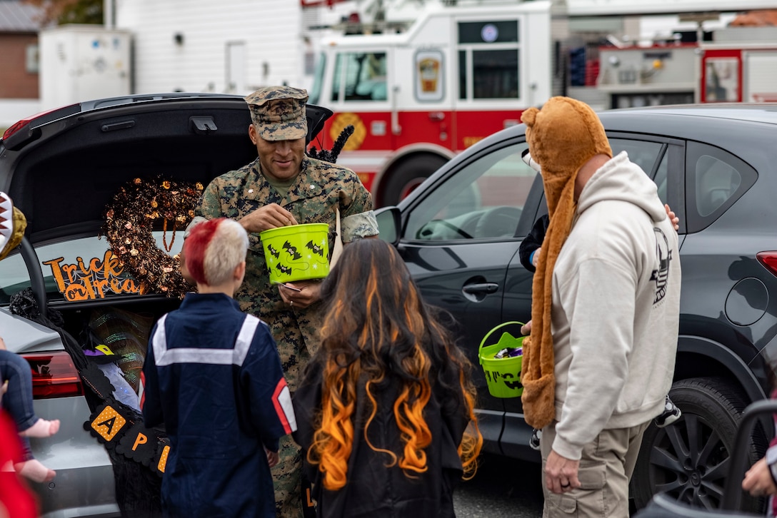 U.S. Marine Corps Lt. Col. David S. Rainey, the commanding officer of Security Battalion, passes out candy during the trunk or treat portion at SECBN’s Haunted Headquarters at Marine Corps Base Quantico, Virginia, Oct. 28, 2022. The Haunted Headquarters included a truck decorating contest, costume contest, kids fair, presentations from the MCBQ Fire Department and Consolidated Substance Abuse Counseling Center, and a haunted maze. (U.S. Marine Corps Photo by Lance Cpl. George Nudo)