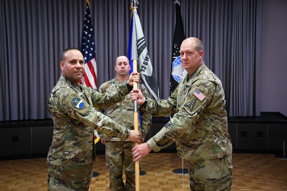 U.S. Space Force Col. Miguel Cruz, Space Delta 4 commander, presents the guidon to Lt. Col. Christopher Castle, incoming 13th Space Warning Squadron commander, during a change of command ceremony June 16, 2022, at Clear Space Force Station. Castle was formerly stationed in California as the Plans Branch Chief of the Combined Space Operations Center. The 13th SWS, located at Clear SFS, Alaska, provides strategic missile warning and space domain awareness by operating and maintaining the Upgraded Early Warning Radar. Passing of a squadron’s guidon is a tradition and symbolizes a transfer of command. (U.S. Air National Guard photo by Senior Master Sgt. Julie Avey)