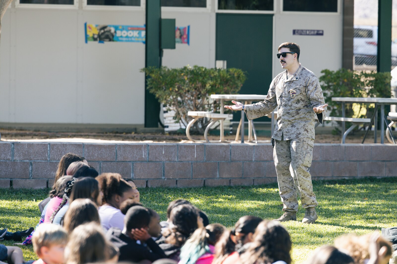 a military working dog handler answers questions from students during a K9 showcase