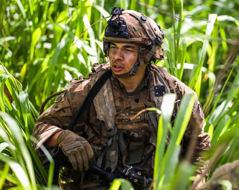 A Soldier from the 25th Infantry Division seeks cover and concealment in a grassy area of land during the Joint Pacific Multi-National Readiness Center rotation 22-01 exercise on Kahuku Training Area, Hawaii on Oct. 25, 2021. JPMRC Rotation 22-01 provides the 25th Infantry Division the opportunity to integrate and train alongside our partners and allies throughout the Indo-Pacific Region. (U.S. Army photo by Sgt. Carlie Lopez/28th Public Affairs Detachment)